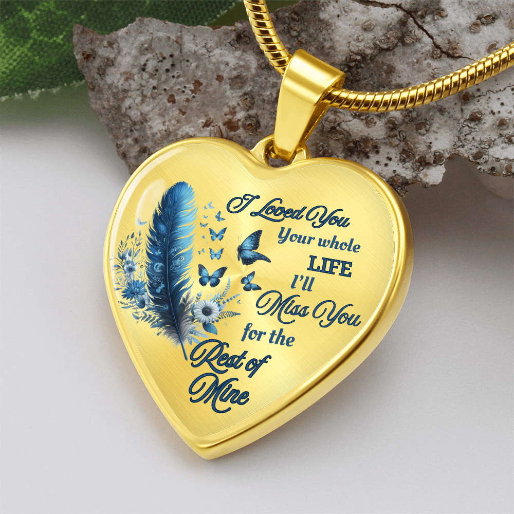 Gold heart-shaped pendant with blue feather, flowers, butterflies, and engraved sentimental message on gold chain.