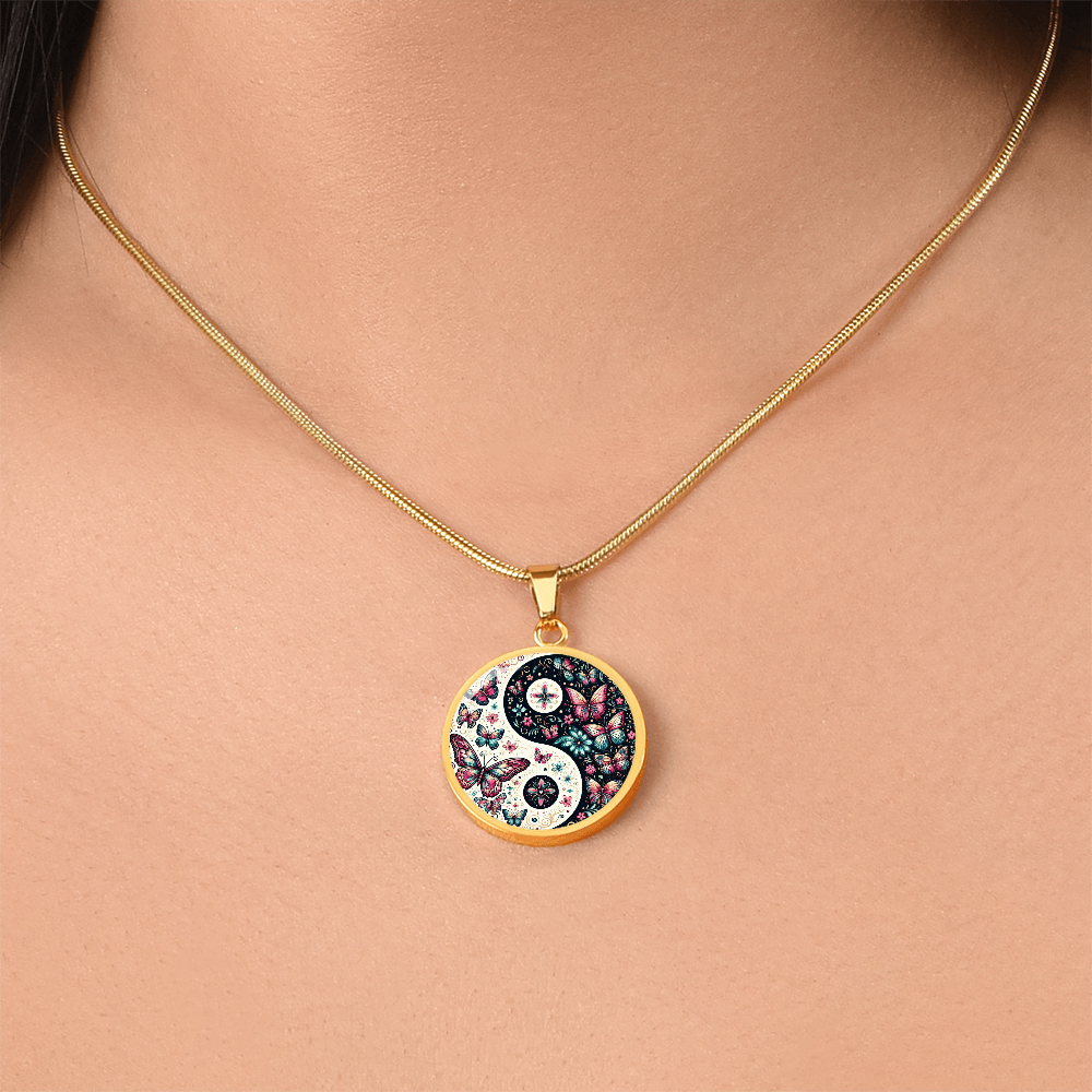 Gold necklace with round yin yang pendant featuring pink butterfly and floral design.