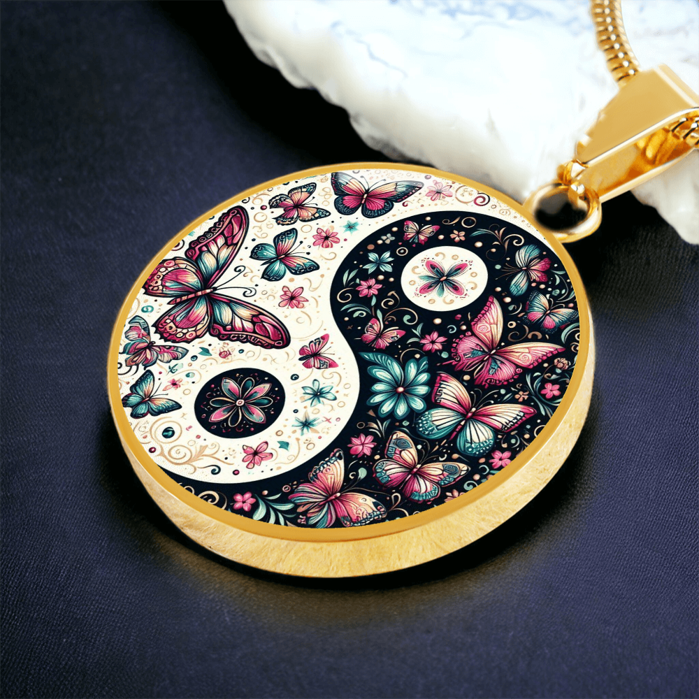Gold circular pendant necklace featuring a yin yang design filled with pink butterflies and floral patterns.