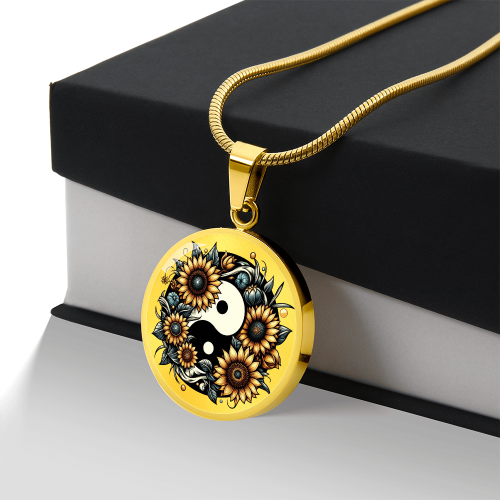Gold circular pendant necklace with yin yang symbol surrounded by detailed sunflowers on black background.