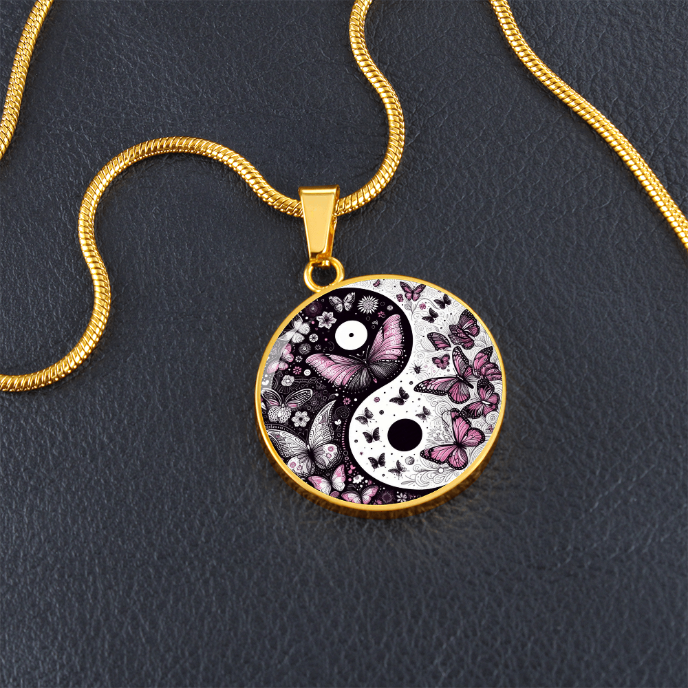 Gold necklace with round yin yang pendant featuring violet butterflies and floral design.