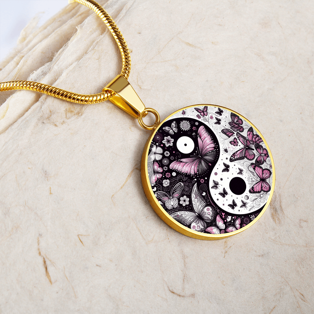 Gold circular pendant necklace featuring a yin yang design with violet butterflies and floral details.