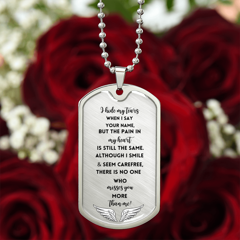 Silver military chain tag necklace with engraved memorial message and angel wings on a red rose background.