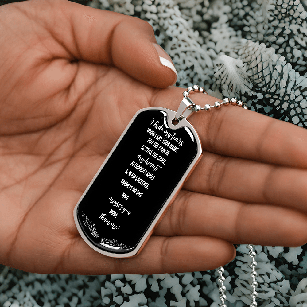 Silver military dog tag necklace with engraved grief remembrance poem held in hand.