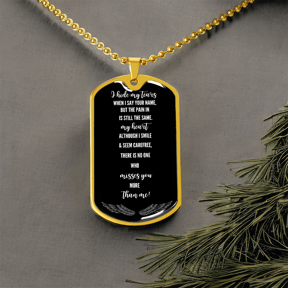 Black military tag necklace with white engraved grief poem on gold ball chain against gray background.