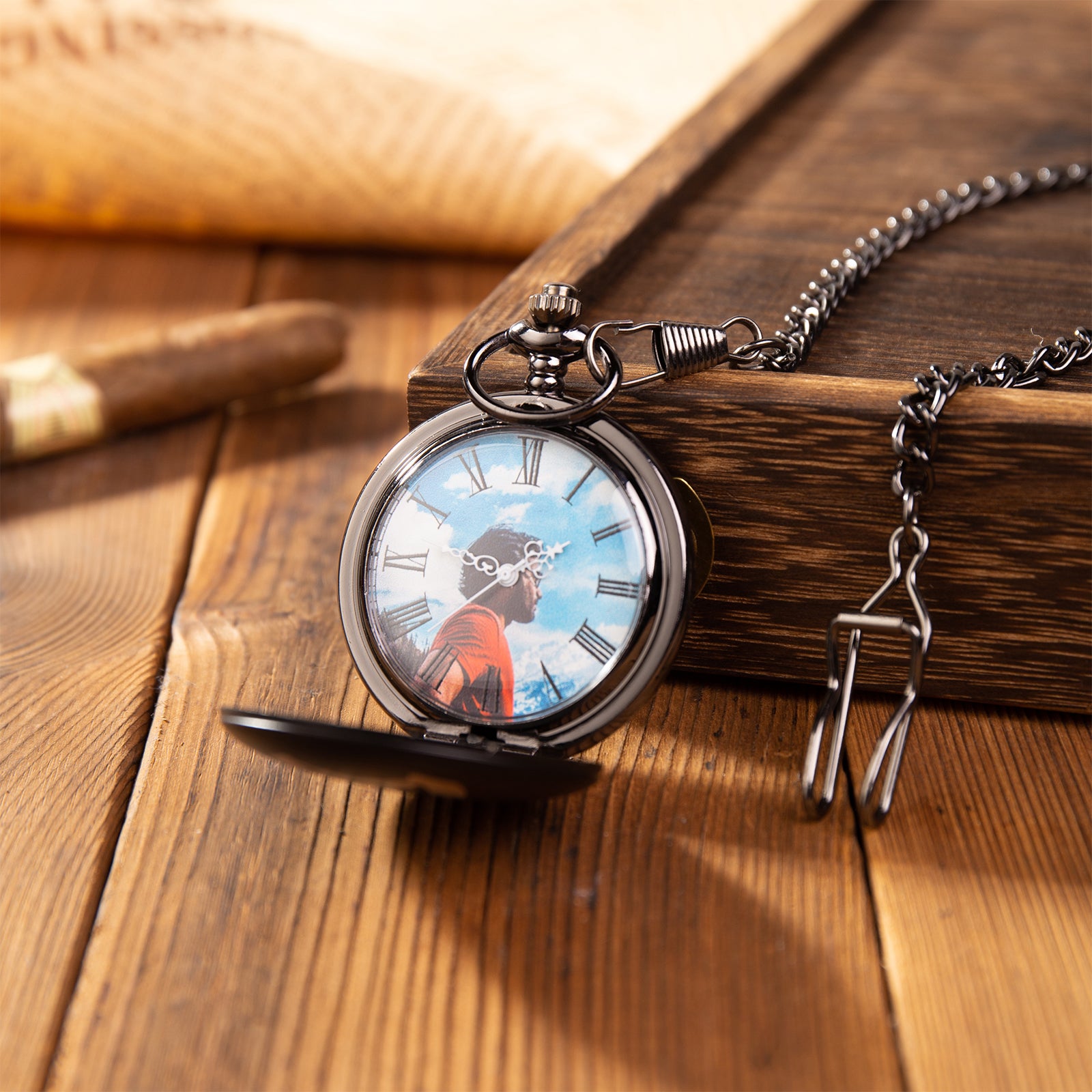 Antique-style pocket watch with custom photo dial, bronze finish, and matching chain on wooden surface.