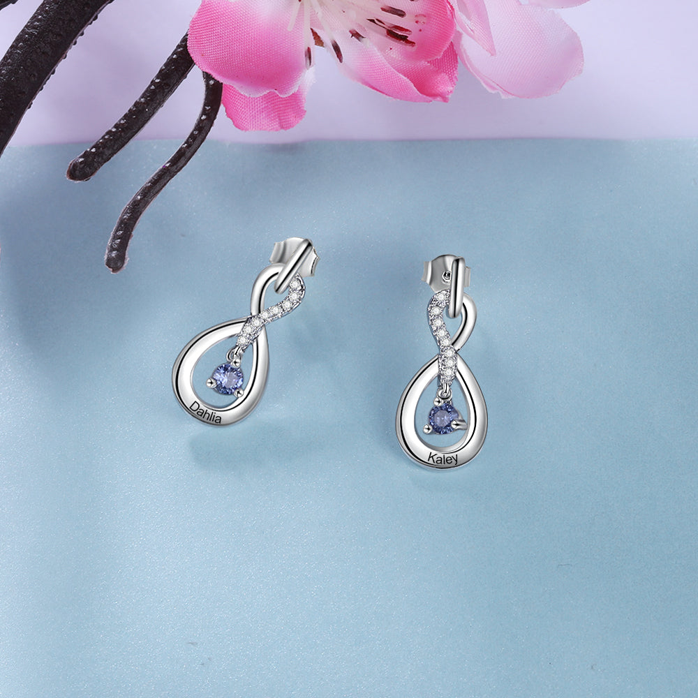 Silver infinity-shaped earrings with blue birthstone accents and delicate loop design.