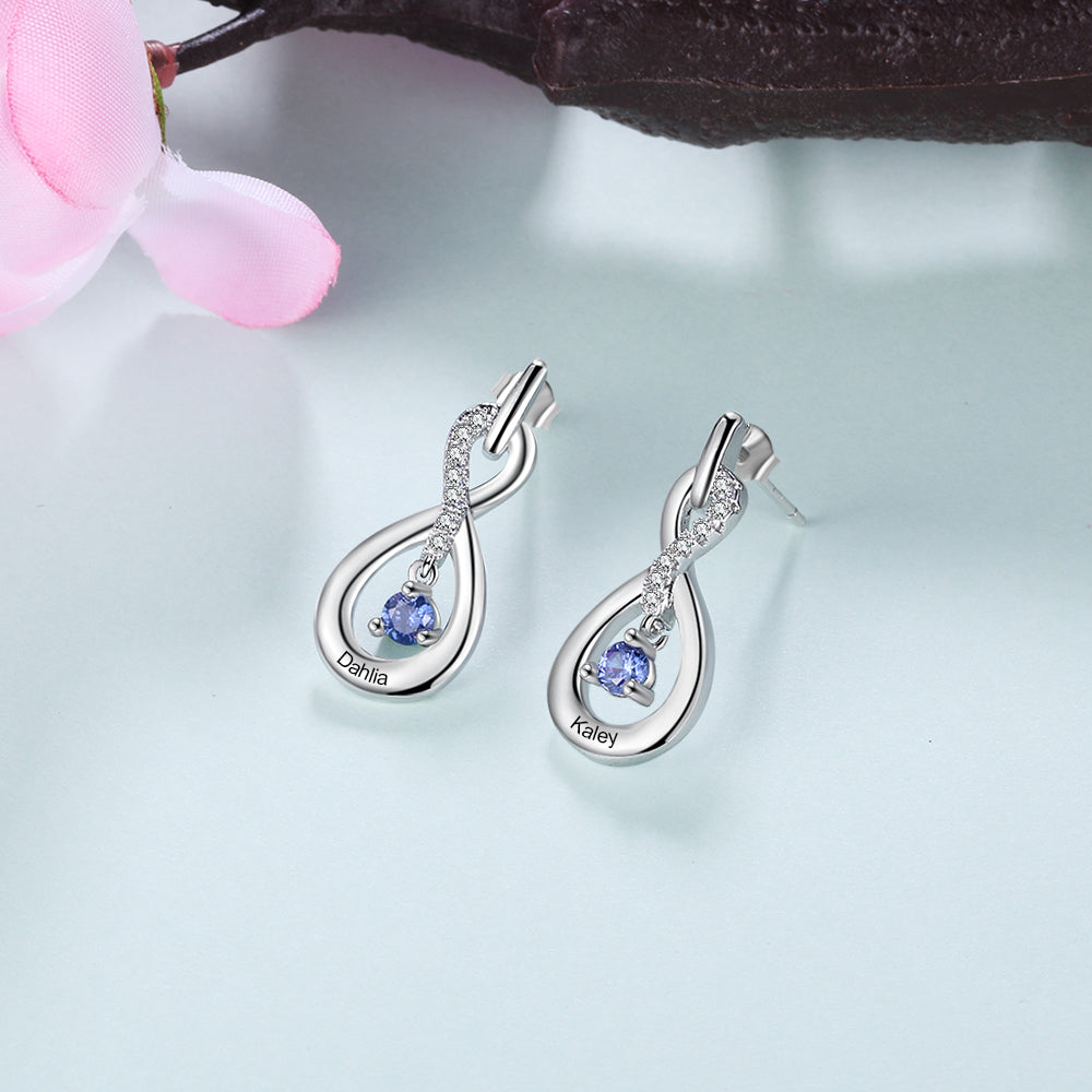 Silver infinity-shaped earrings with blue birthstone and small clear crystals.