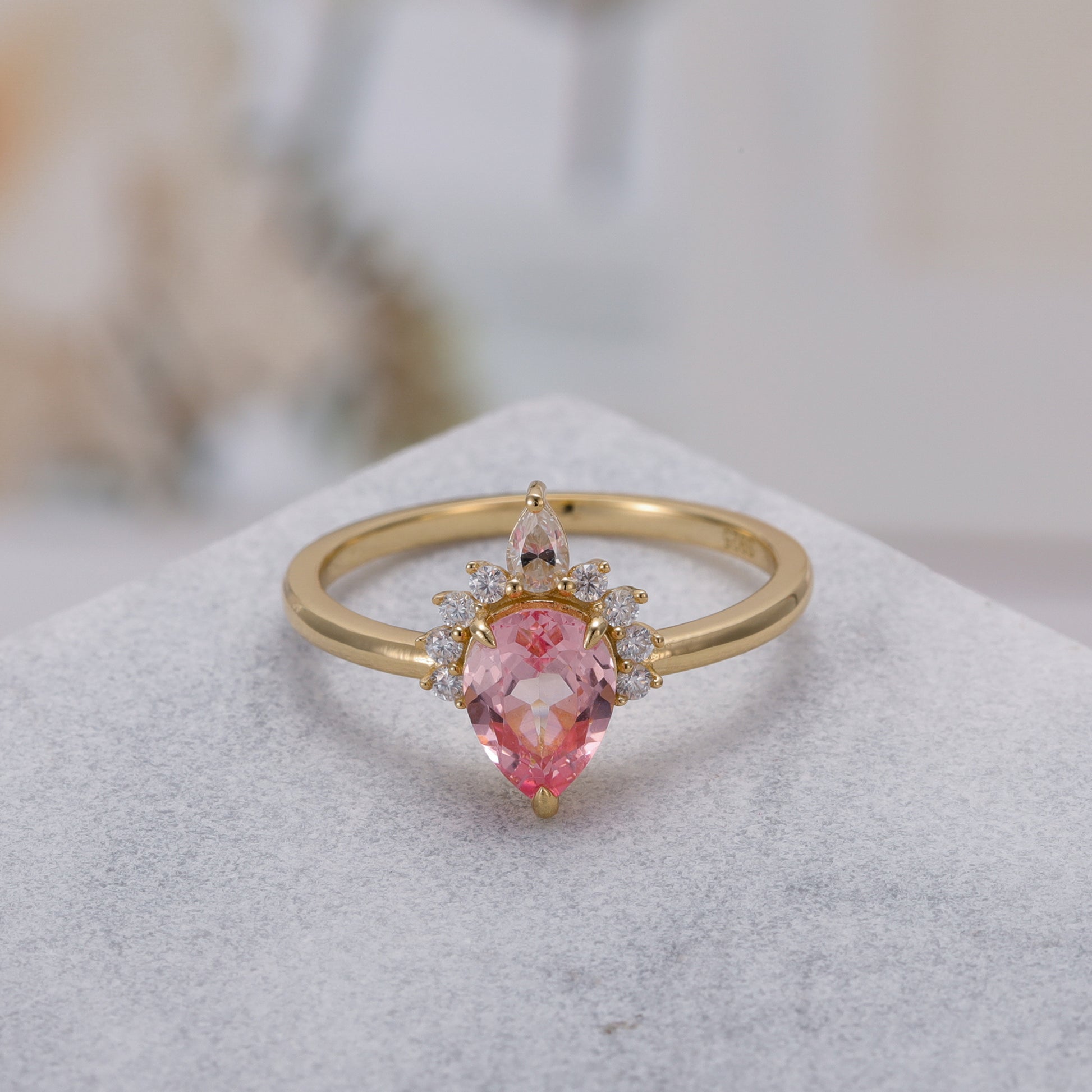 925 Sterling Silver Lab Pink Sapphire Ring with pear-shaped pink sapphire and gold plated band on a light background