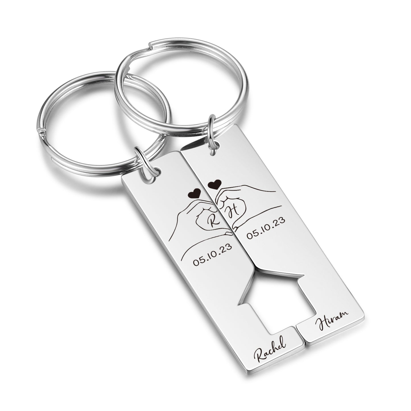 Pair of rectangular stainless steel keychains with interlocking heart cutout, engraved hands forming a heart, date, and.