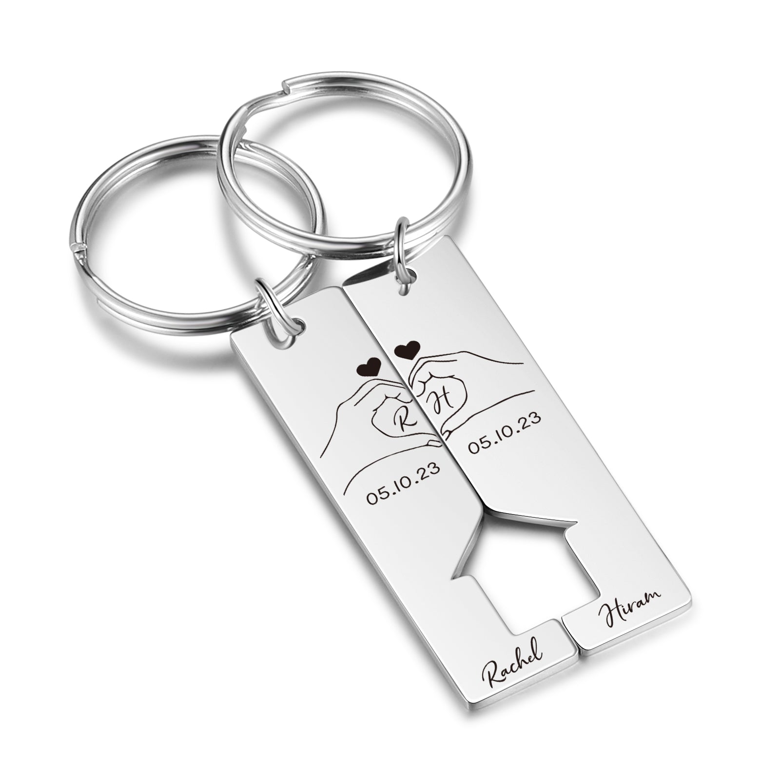 Pair of rectangular stainless steel keychains with interlocking heart cutout, engraved hands forming a heart, date, and.