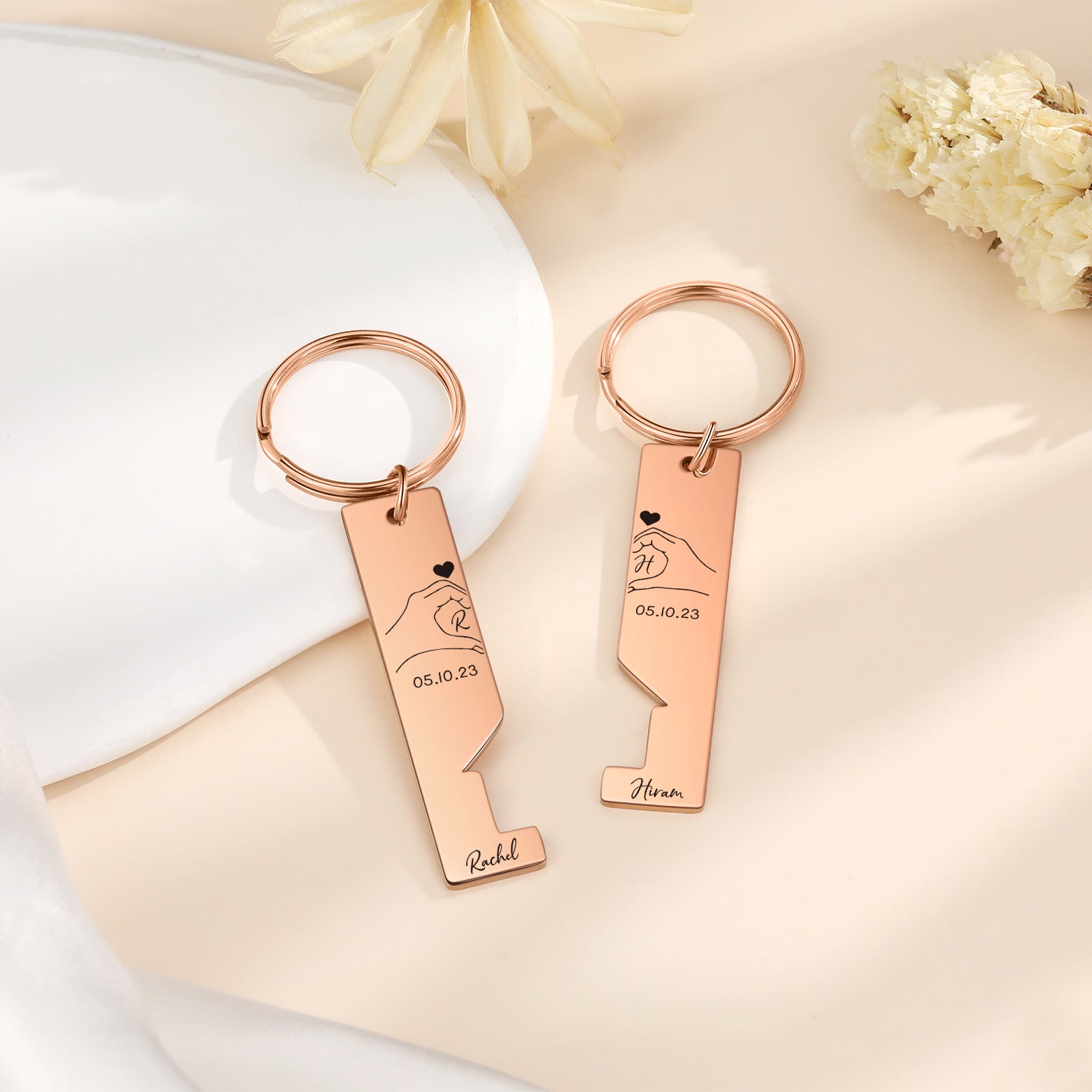 Rose gold stainless steel couple keychains with interlocking puzzle pieces, engraved initials and a heart design.