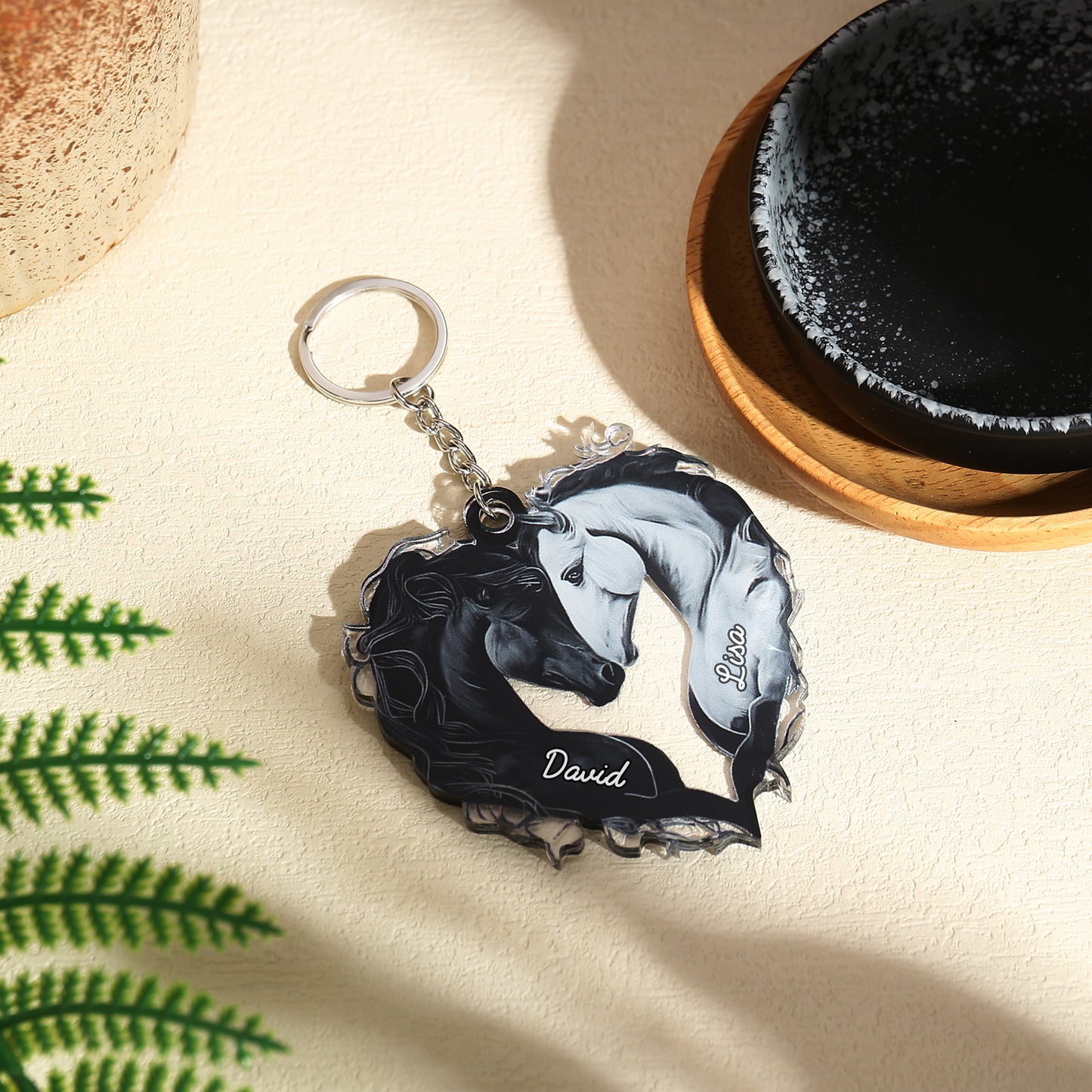 Acrylic heart-shaped keychain featuring black and white horses forming the heart with a personalized name "David" in white.