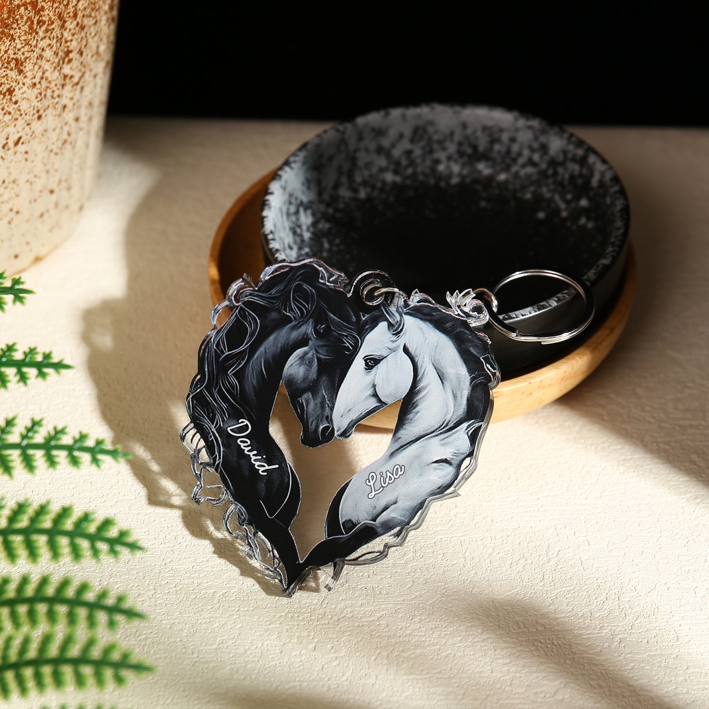 Black and white acrylic heart-shaped keychain featuring two horses nuzzling with engraved names.