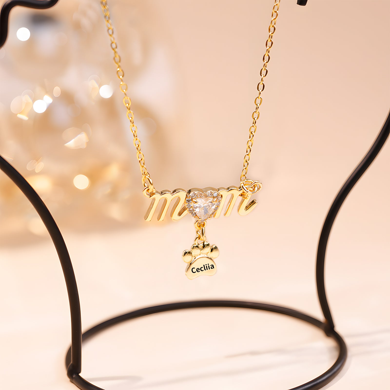 Gold Mother's Day necklace with paw print charm and sparkling heart detail.
