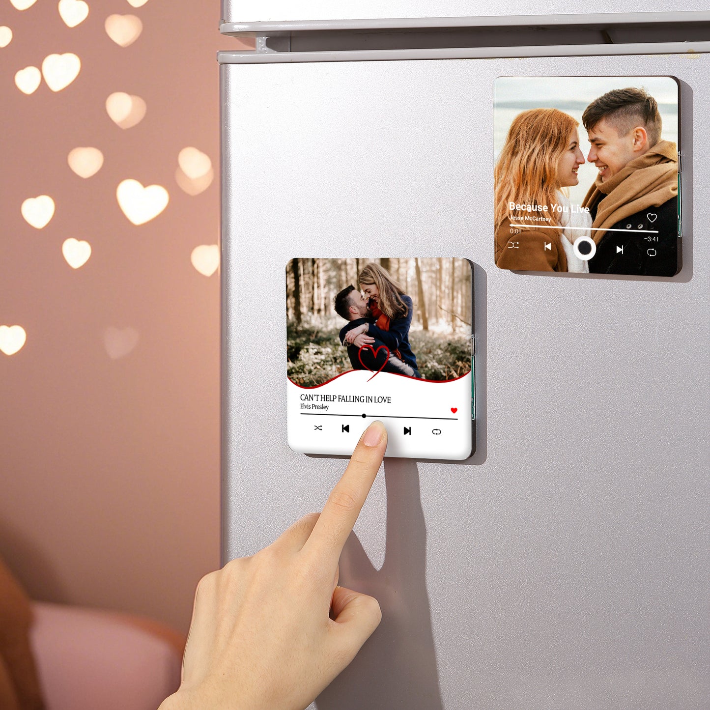 Refrigerator with two personalized song magnets; one showing a couple embraced in a forest, the other a couple smiling face to face. A hand touches the "Can't Help Falling In Love" magnet.