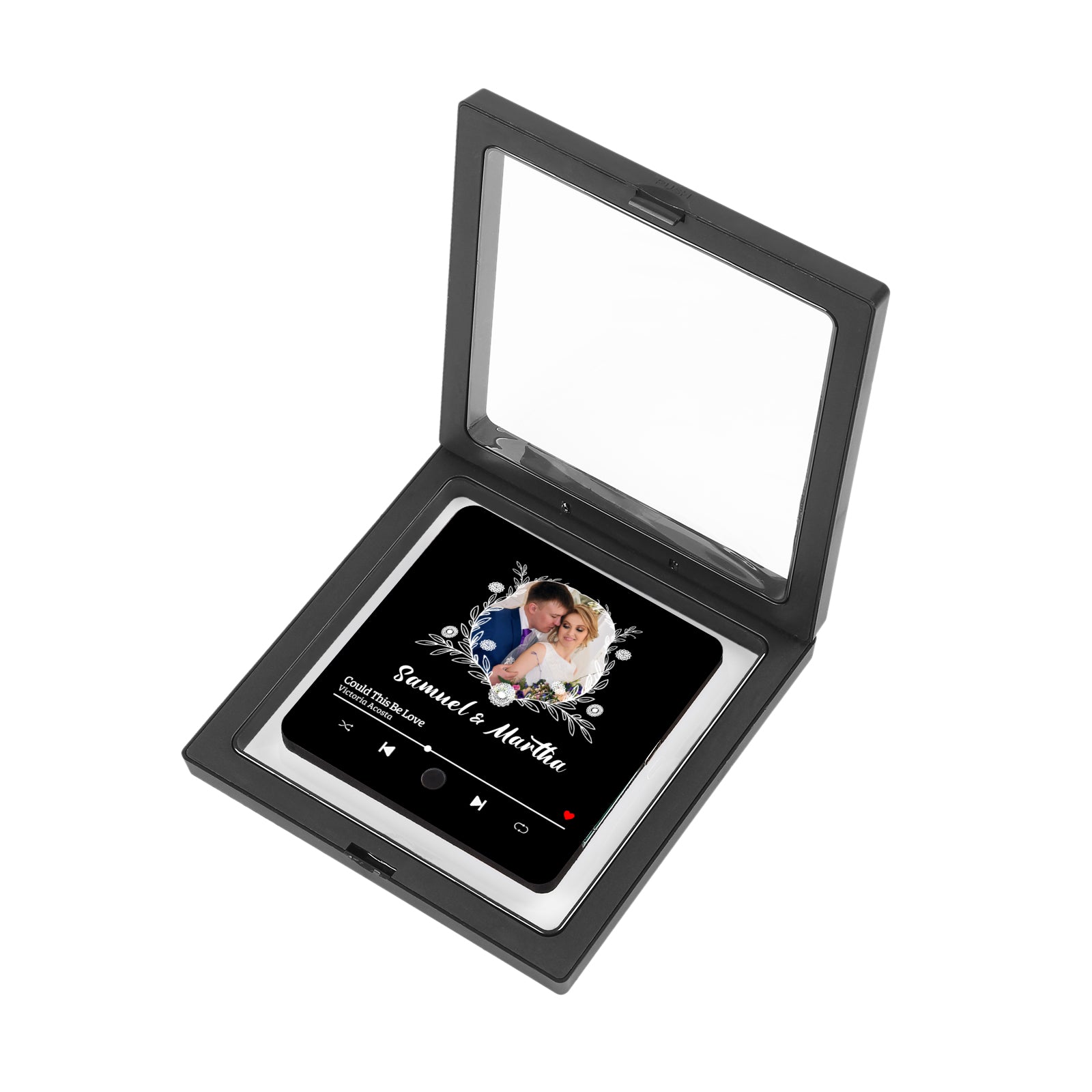 A black shadow box containing a black tile with a wedding photo and music player-style design.