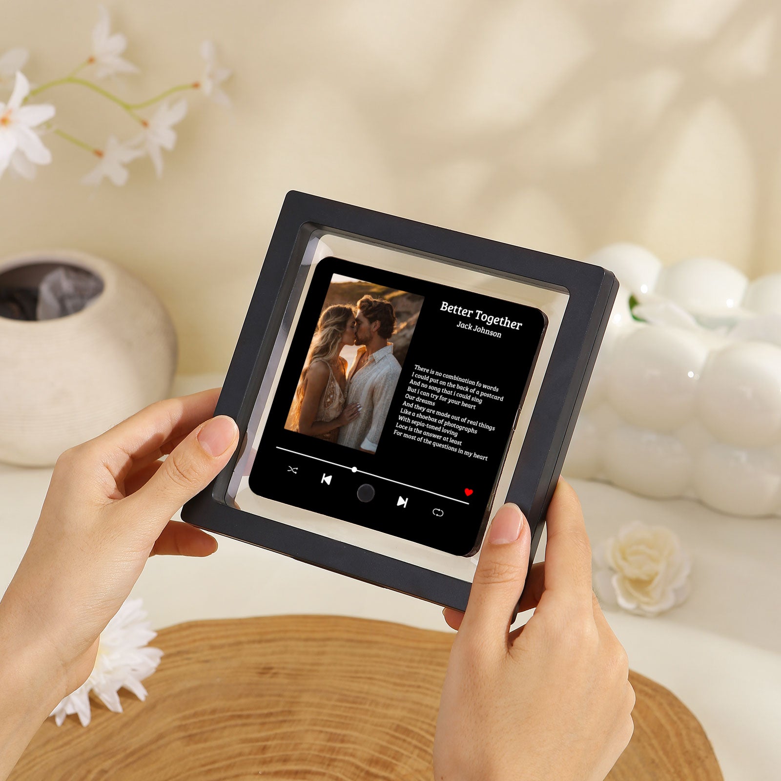 Hands holding a black framed art print with the "Better Together" song title and a couple kissing.