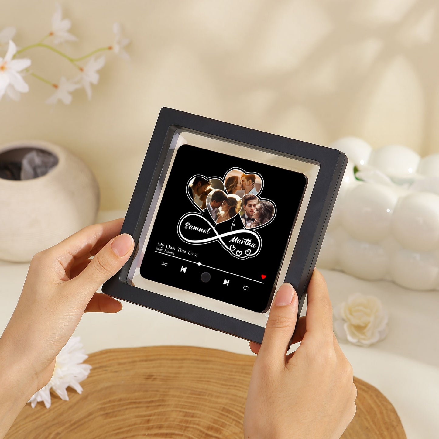 Hands holding a framed photo collage of a couple, designed like a music player screen.