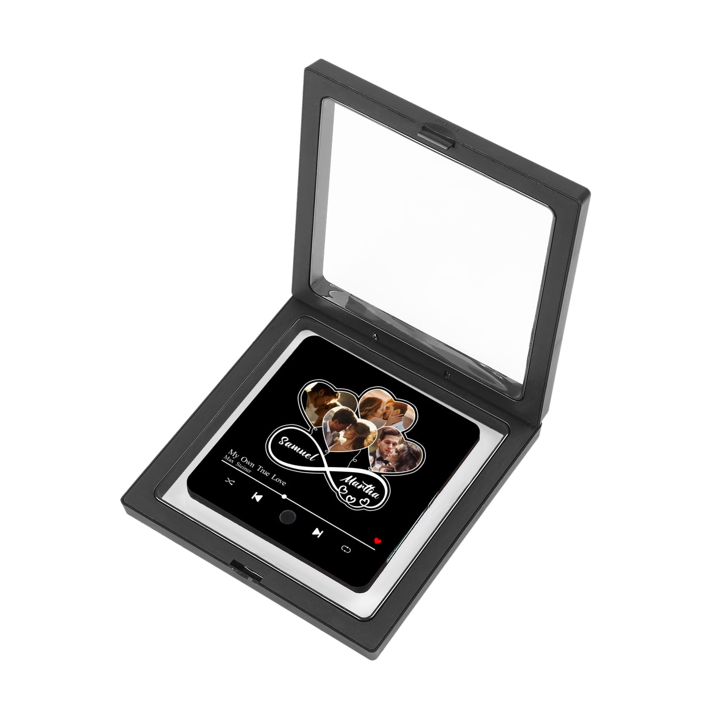 A black, hinged shadow box displays a personalized item inside. The item features photos inside heart shapes above the names Samuel and Martha, along with a music player design.
