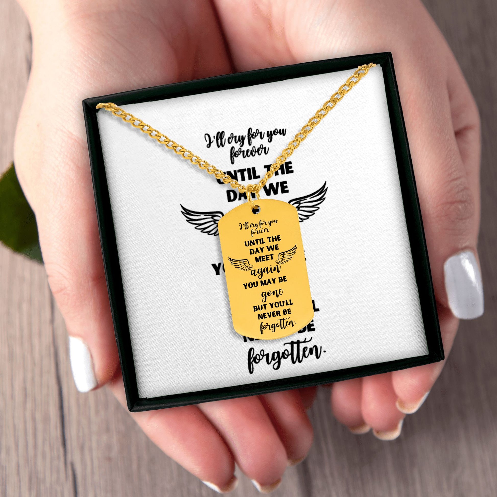 18k gold plated memorial dog tag necklace with engraved sentimental message and wings design in black gift box held in hands.